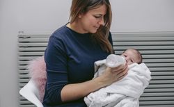 Mother giving bottle to her newborn