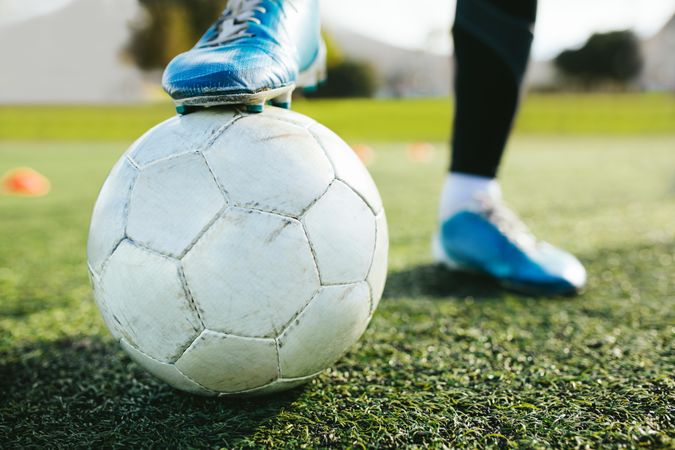 Cropped shot of soccer player’s foot on top of soccer ball