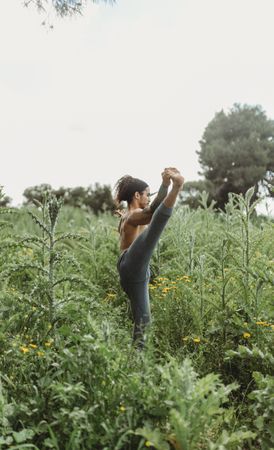 Man training yoga on meadow