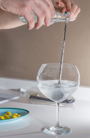 Barman pouring drink to prepare gin tonic cocktail