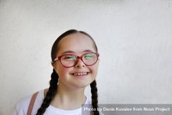Young girl smiling and wearing glasses 0KPDN5