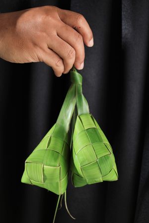 Female Hand Holding Rice Package Made from Young Coconut Leaves
