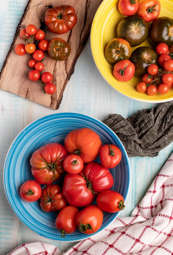 Napkins near bowls and board with tomatoes