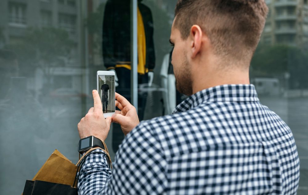 Man taking a photo of a shop window of a store