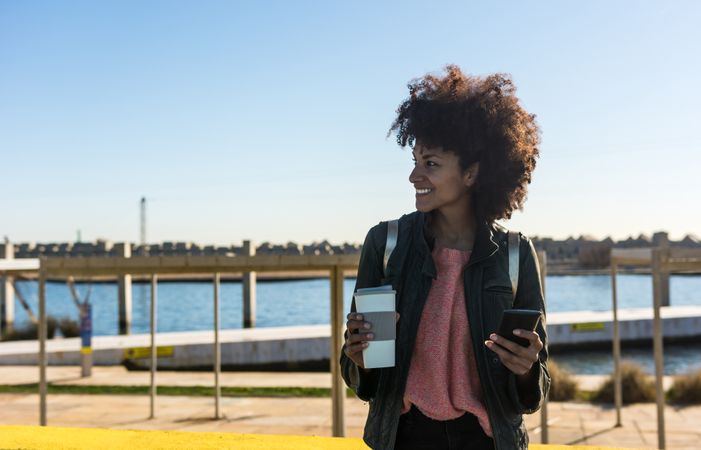 Black woman with afro hair leaning against brightly colored wall