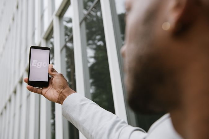 Person holding smartphone with text Ego on screen
