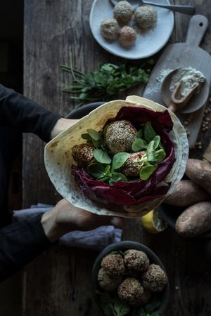 Hands with fresh sweet potato falafel