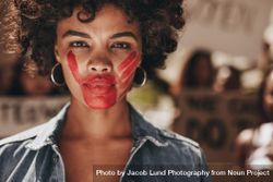 Female activist with a hand print on her mouth, demonstrating violence on women 5QLRX0