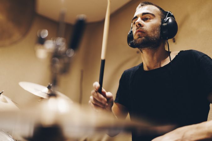 Man with headphones playing on drums