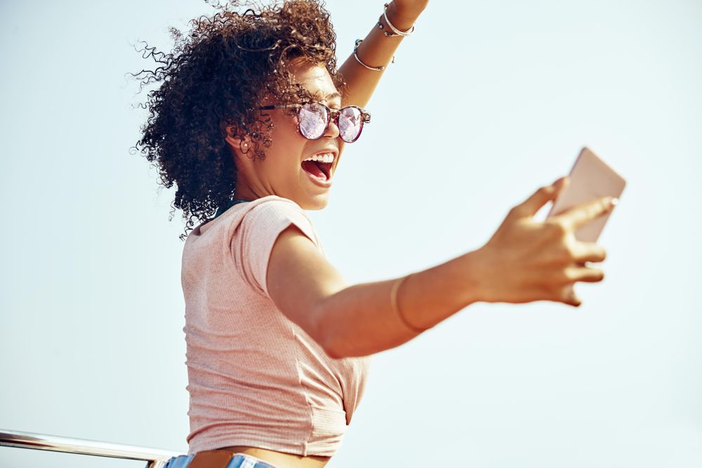 Happy woman taking a selfie outside in the summer