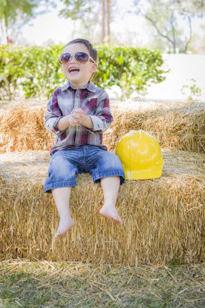 Boy Laughing Outside with Sunglasses and Hard Hat
