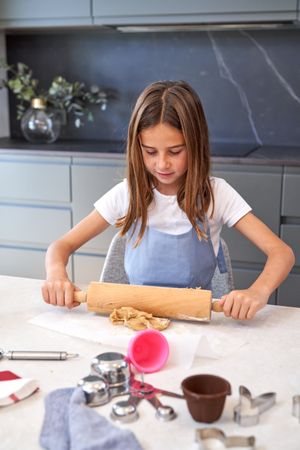 Girl rolling out cookie dough