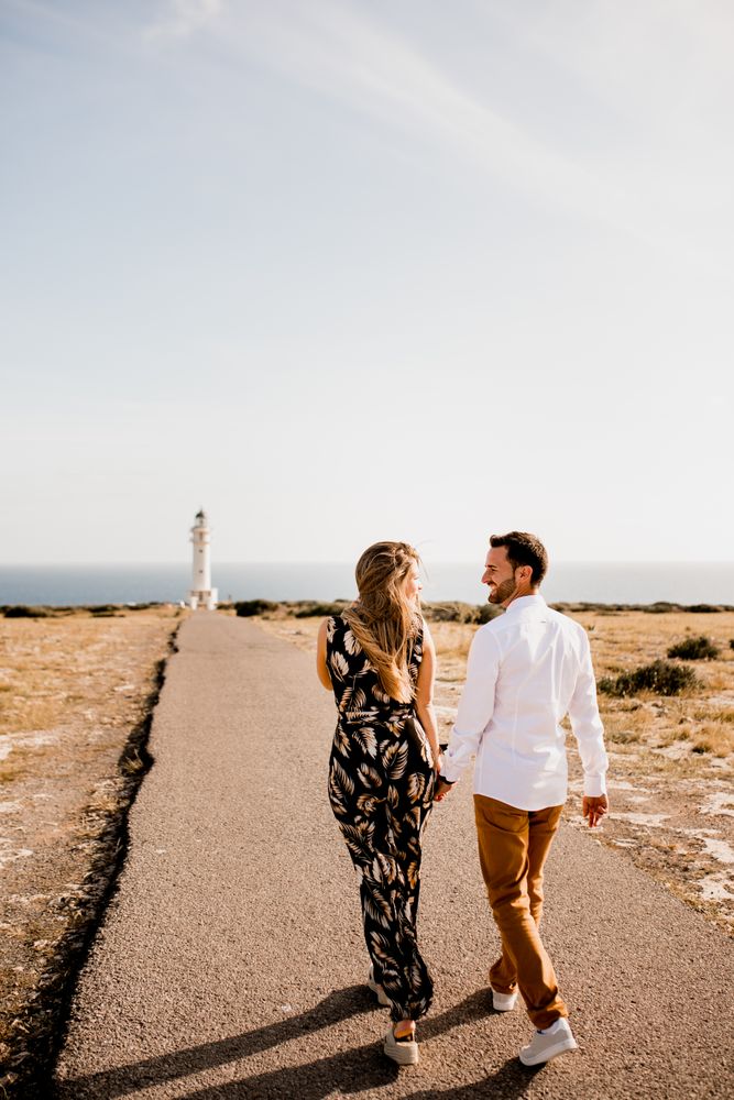 Smiling lovers cuddling on path to sea