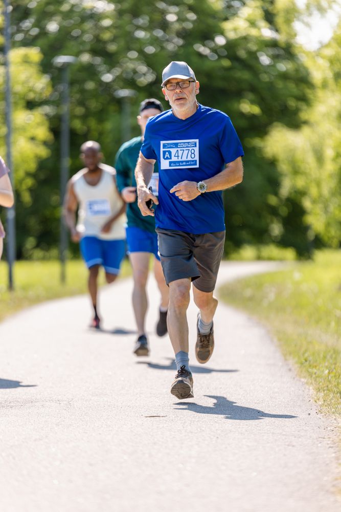 Portrait of a Older Male Jogger Running in a Park on a Health Trail.