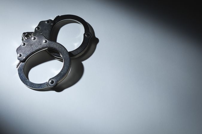 Abstract Pair of Handcuffs Under Spot Light - Text Room