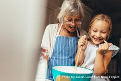 Happy grandmother and child mixing cake batter at home 0vyQxb