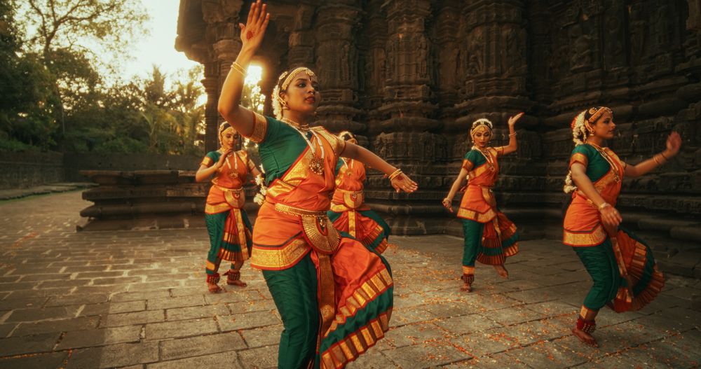 Portrait of Indian Women in Traditional Clothes Dancing Bharatanatyam in Colourful Sari.