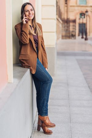 Pleased female in stylish outfit on street smiling away