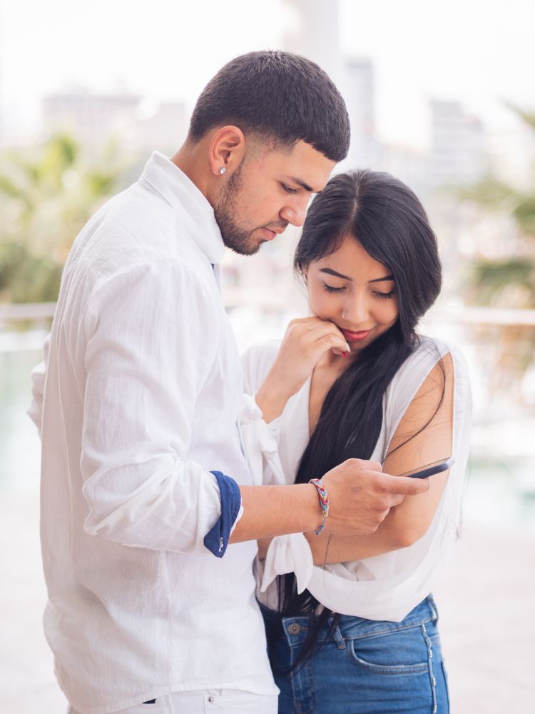 Man messaging on smartphone standing with woman