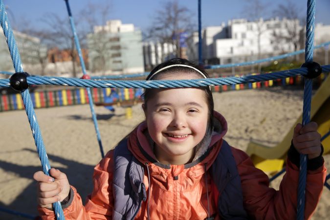 Portrait of little girl playing on playset smiling and looking at camera