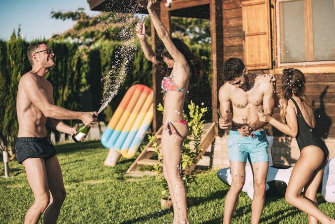 Guy pouring champagne over his friends