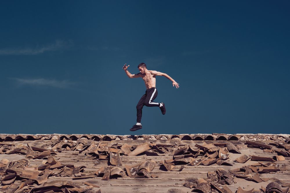 Active sportsman running and jumping on rooftop