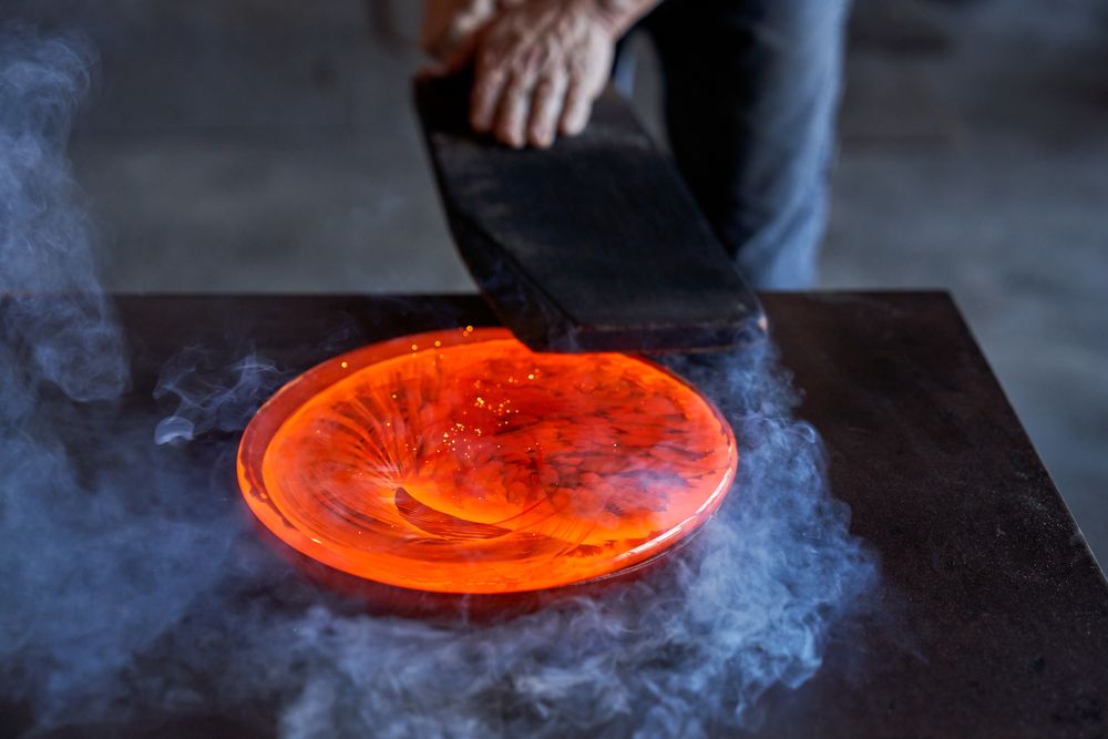 Male master working with hot orange glass