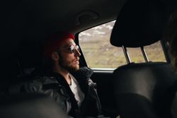 Male in sunglasses observing scenery from vehicle window