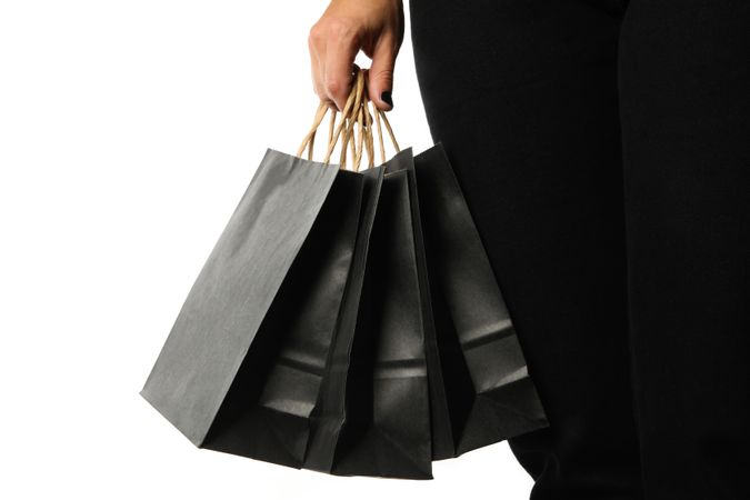 Female hand hold paper bags, isolated on bright background