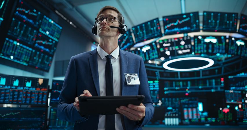 Portrait of a Successful Stock Exchange Manager Wearing Headphones, Working in Modern Office.