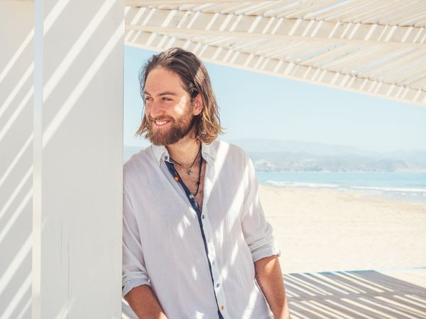 Relaxed man standing in gazebo on beach