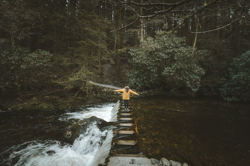 Man crossing river on stepping stones