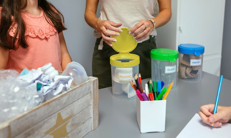 Teacher showing how to recycle by sorting waste in ecology classroom