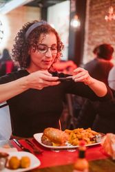 Young woman taking photo of food
