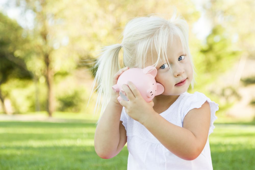 Little Girl Having Fun with Her Piggy Bank Outside