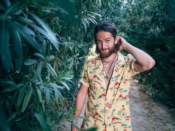 Hipster man walking in the jungle