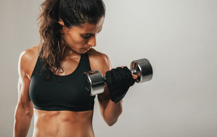 Close up of woman curling dumbbell