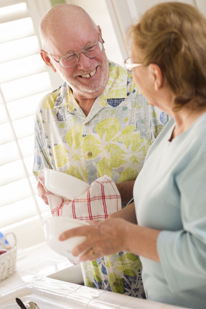 Adult Couple Washing Dishes Together Inside Kitchen