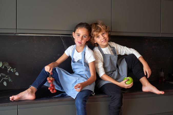 Cute children with fruits looking at camera