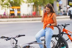 Woman talking with mobile waiting on public rental bike station