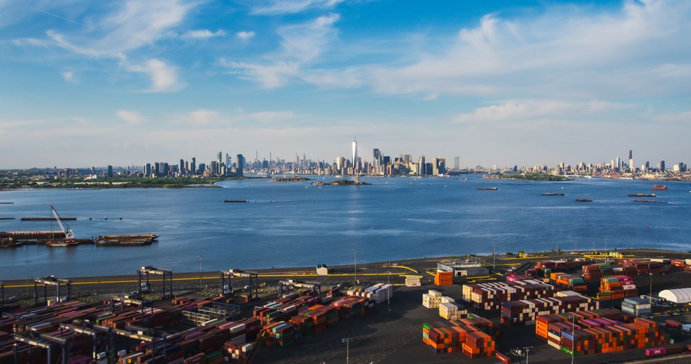 Aerial View of Manhattan Architecture. Panorama of New York City and Jersey City From a Helicopter, Showing Office Buildings and Skyscrapers. Camera Flies Over a Harbour Area with Shipping Containers