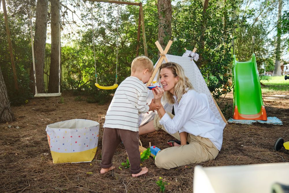 Mother and son playing with toys in playground