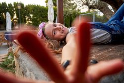 Cheerful girl with outstretched hand in backyard in countryside