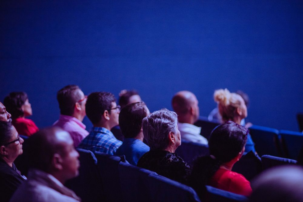 People sitting on chair in front of stage
