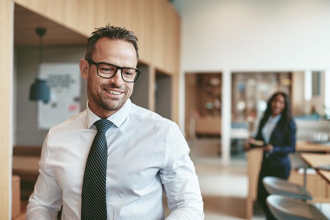 Business man in glasses smiling while leaving meeting