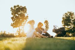 mother and daughter in the park with a baby