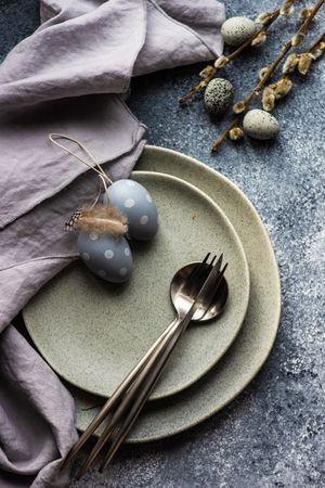 Easter holiday table setting with grey eggs, grey plate and grey counter