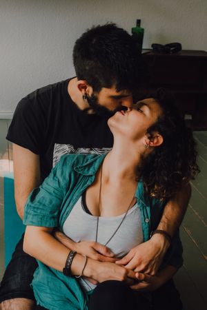 hipster couple kissing and cuddling at home