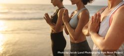 Group of women with joined hands during yoga class 56w8l4