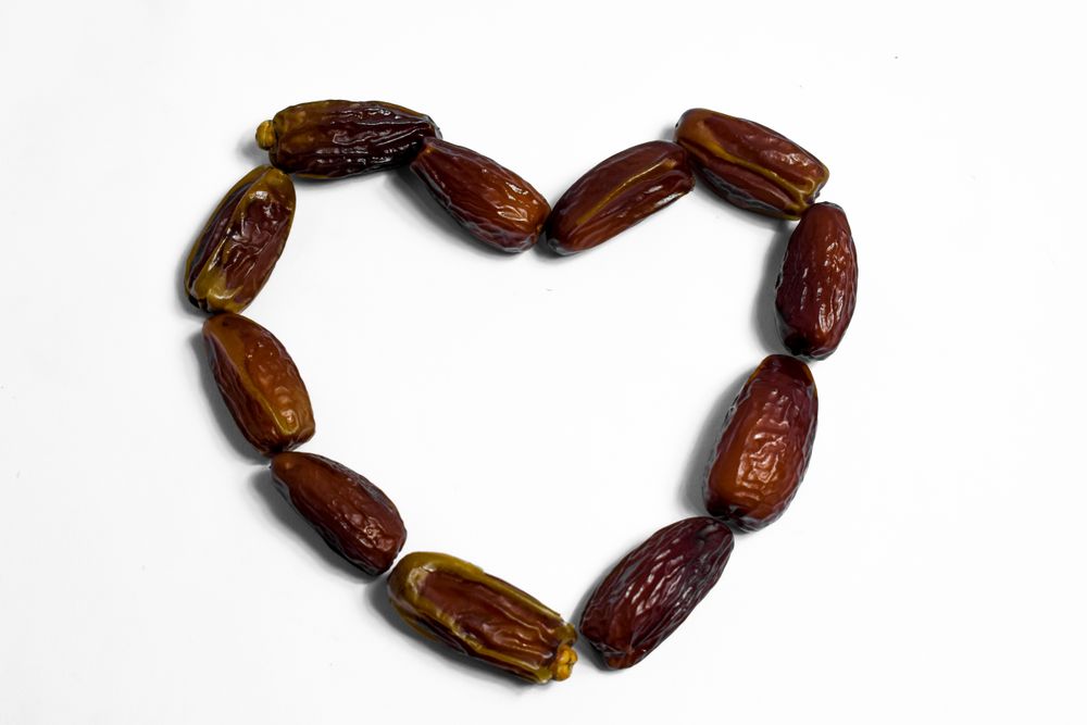 Dates fruit in love shape on isolated blank background